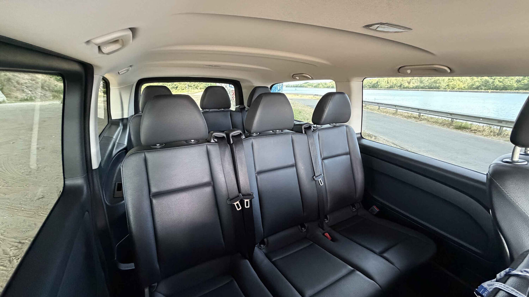 Ruim interieur met meerdere rijen lederen zetels in de Mercedes Vito