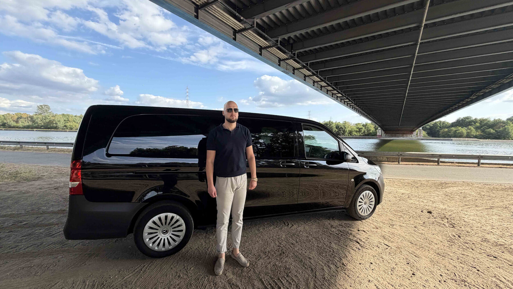 De Mercedes Vito van Taxi Sander onder de brug bij het kanaal